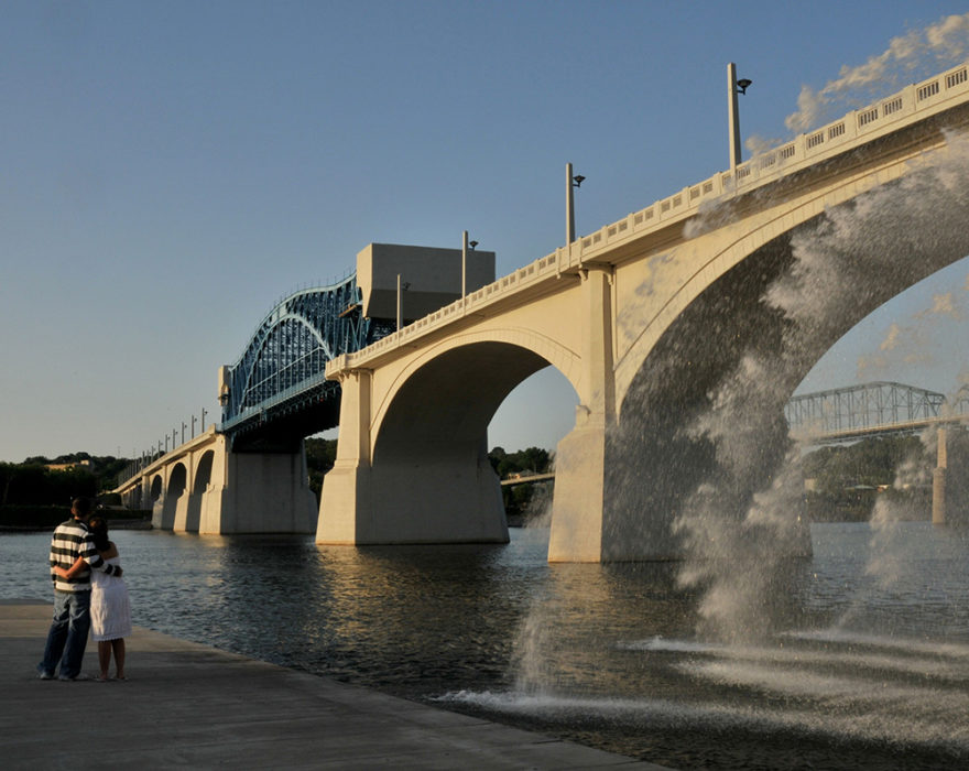 Two people embrace in front of the Market Bridge in downtown Chattanooga, TN