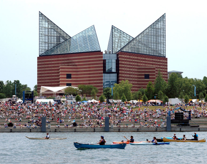 Several people canoe and kayak down the river in Chattanooga, TN in front of the Tennessee Aquarium